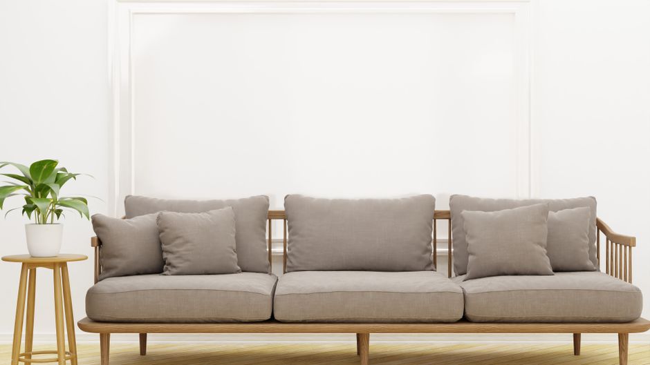 Elegant and cozy modern sofa with neutral tone pillows in a minimalist living room setting.