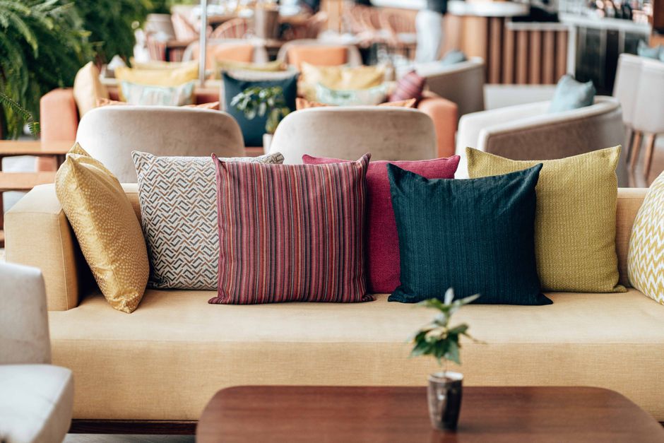 A cozy seating area with vibrant throw pillows on a modern yellow sofa in a stylish indoor setting.